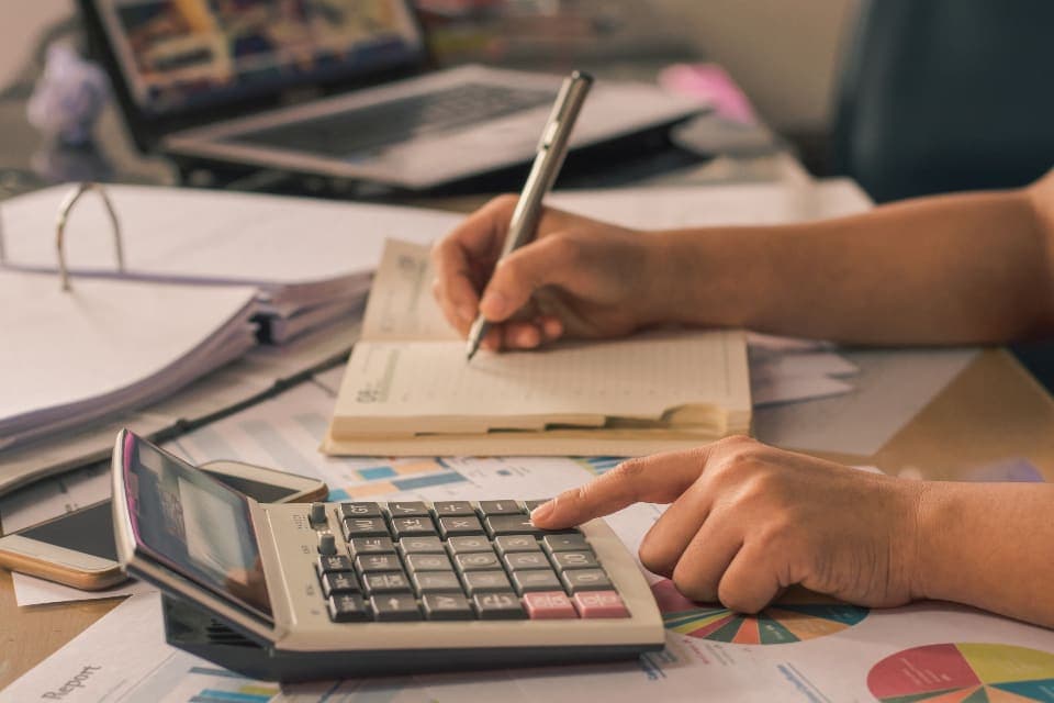 Persona revisando cuentas con una calculadora