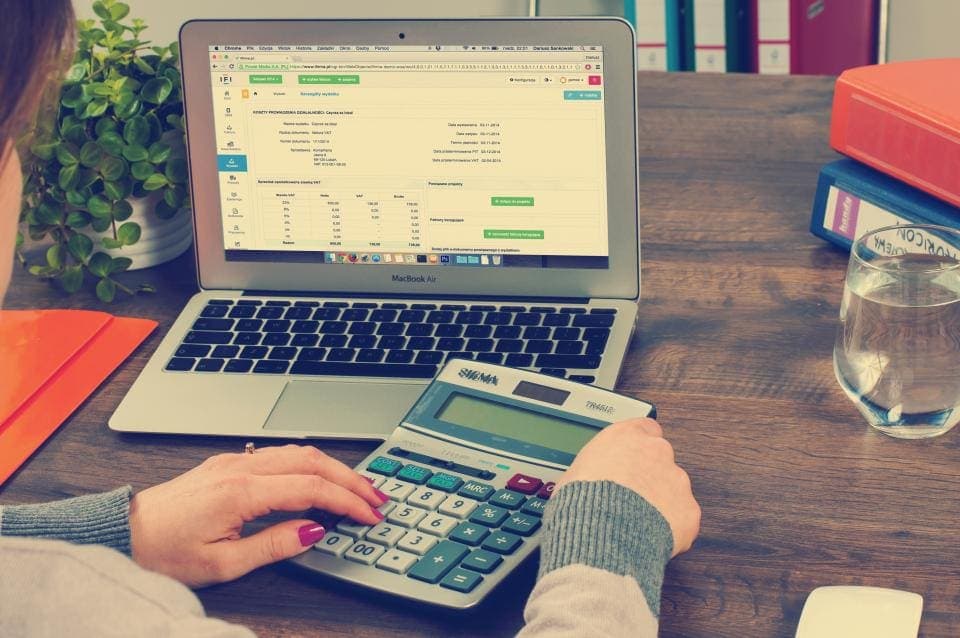 Contadora trabajando con laptop y calculadora